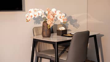 A dining table with a vase of flowers, a tissue box, and a tray.