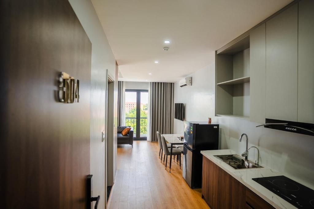 A modern kitchen with a built-in stove, a dining area with a table and chairs, and a view of the outdoors through a glass door.
