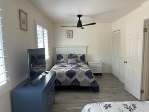 A bedroom with a bed, dresser, nightstand, and a ceiling fan. - Cozy  studio in welcoming Indio with AC (Indio)
