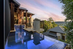 A modern outdoor pool area with a view of a cityscape and mountains in the background. - Far Pavilions Villa A - Luxe Hillside Escape (Port Douglas)
