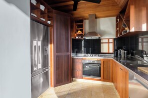 A kitchen with wooden cabinets, a stainless steel refrigerator, a stove, and a dishwasher. - Far Pavilions Villa A - Luxe Hillside Escape (Port Douglas)