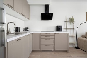 Eine moderne Küche mit Einbauherd, Mikrowelle und Kaffeemaschine.