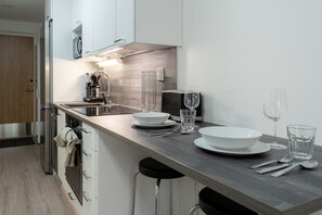 A modern kitchen with a central island, stainless steel appliances, and bar stools. - Levi South Studio 1, Private Sauna By Lapland Host (Levi)