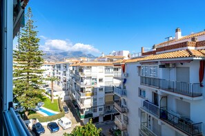 A residential area with multi-story buildings, a swimming pool, and a mountain backdrop. - Studio in Nerja Near Torrecilla Beach (Nerja)