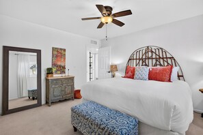A bedroom with a bed, a ceiling fan, a dresser, a mirror, and a door. - Private Pool + Hot Tub + Fire Pit + Covered Patio | Mins to Golf | Casa Talavera (Scottsdale)