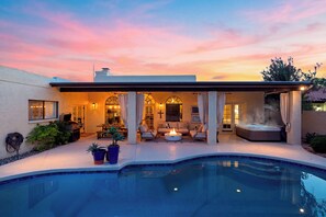 Un espacio exterior moderno con piscina, mobiliario de patio y bañera de hidromasaje.