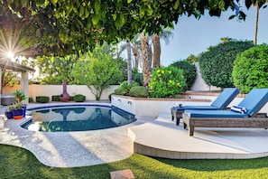 A pool area with a curved pool, lounge chairs, and surrounding greenery. - Private Pool + Hot Tub + Fire Pit + Covered Patio | Mins to Golf | Casa Talavera (Scottsdale)