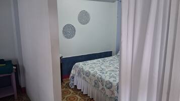 Una habitación con una cama, una alfombra estampada y una pared con adornos circulares.