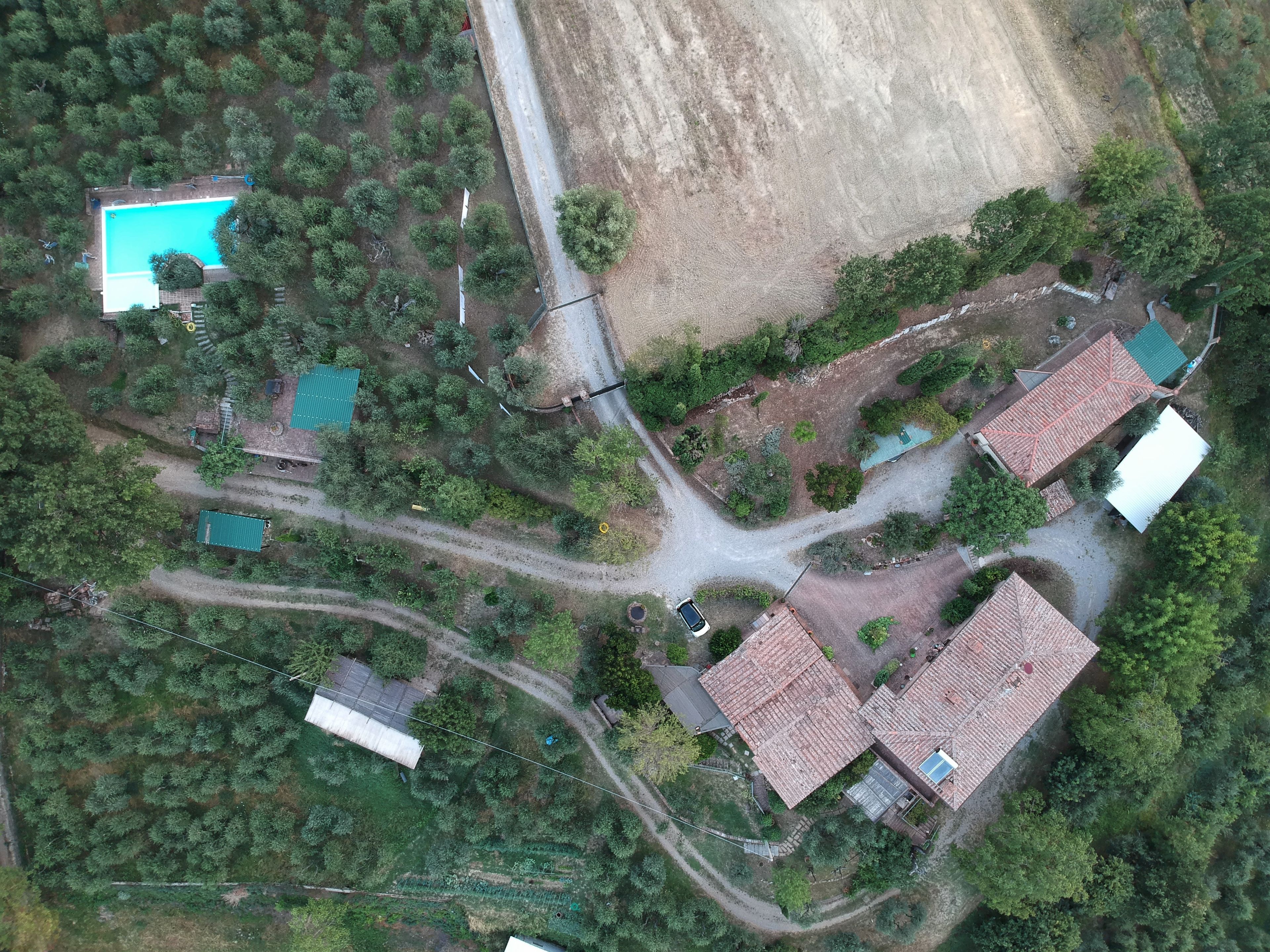 Vue aérienne d’un quartier résidentiel avec plusieurs maisons, une piscine et une route.