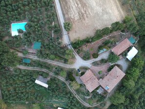 Vue aérienne d’un quartier résidentiel avec plusieurs maisons, une piscine et une route.
