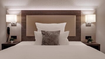 Habitación de hotel con una cama grande, dos lámparas de noche, un teléfono y una pequeña planta en cada mesita de noche.