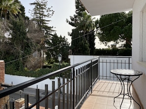 A balcony with a tiled floor, a metal railing, and a small round table. - Holiday Home in Nerja Near Playa Carabeillo (Nerja)