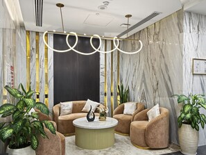 Ein stilvoller Lounge-Bereich mit bequemen Sitzmöglichkeiten, einem zentralen Couchtisch und Zierpflanzen.
