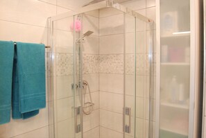 A glass-enclosed shower stall with a handheld showerhead and a handheld shower attachment. - Villa in Nerja Near Burriana Beach & Pool (Nerja)