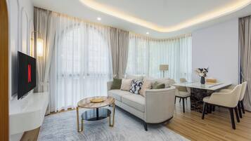 Una sala moderna con un sofá, una mesa de centro, televisor y comedor.