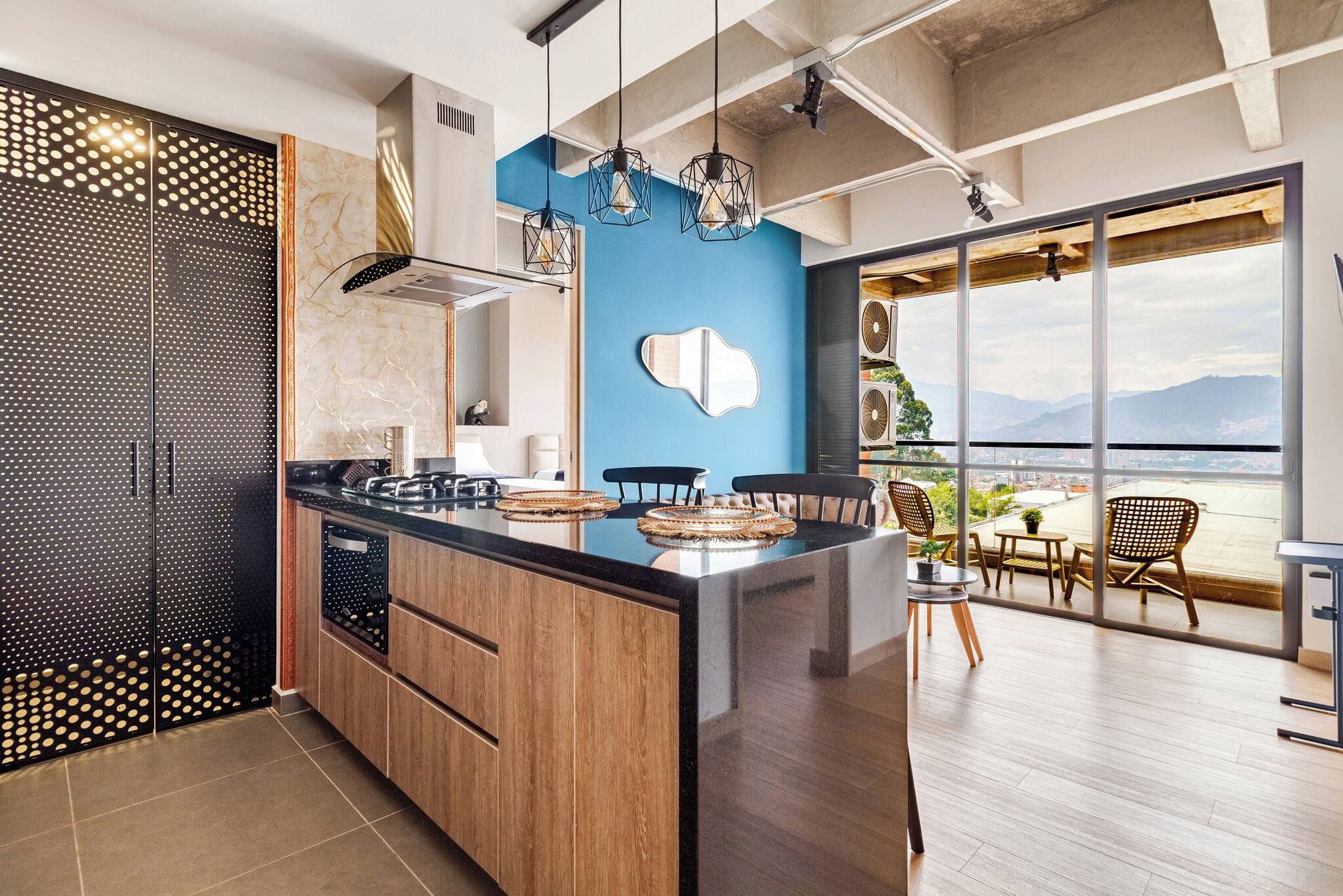 Una cocina moderna con una isla grande, una pared de acento azul y vistas al exterior.