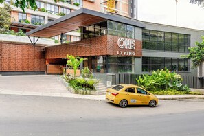 A modern building with a sign reading 'ONE LIVING'. - One Living Luxe Mall City Plaza (Envigado)