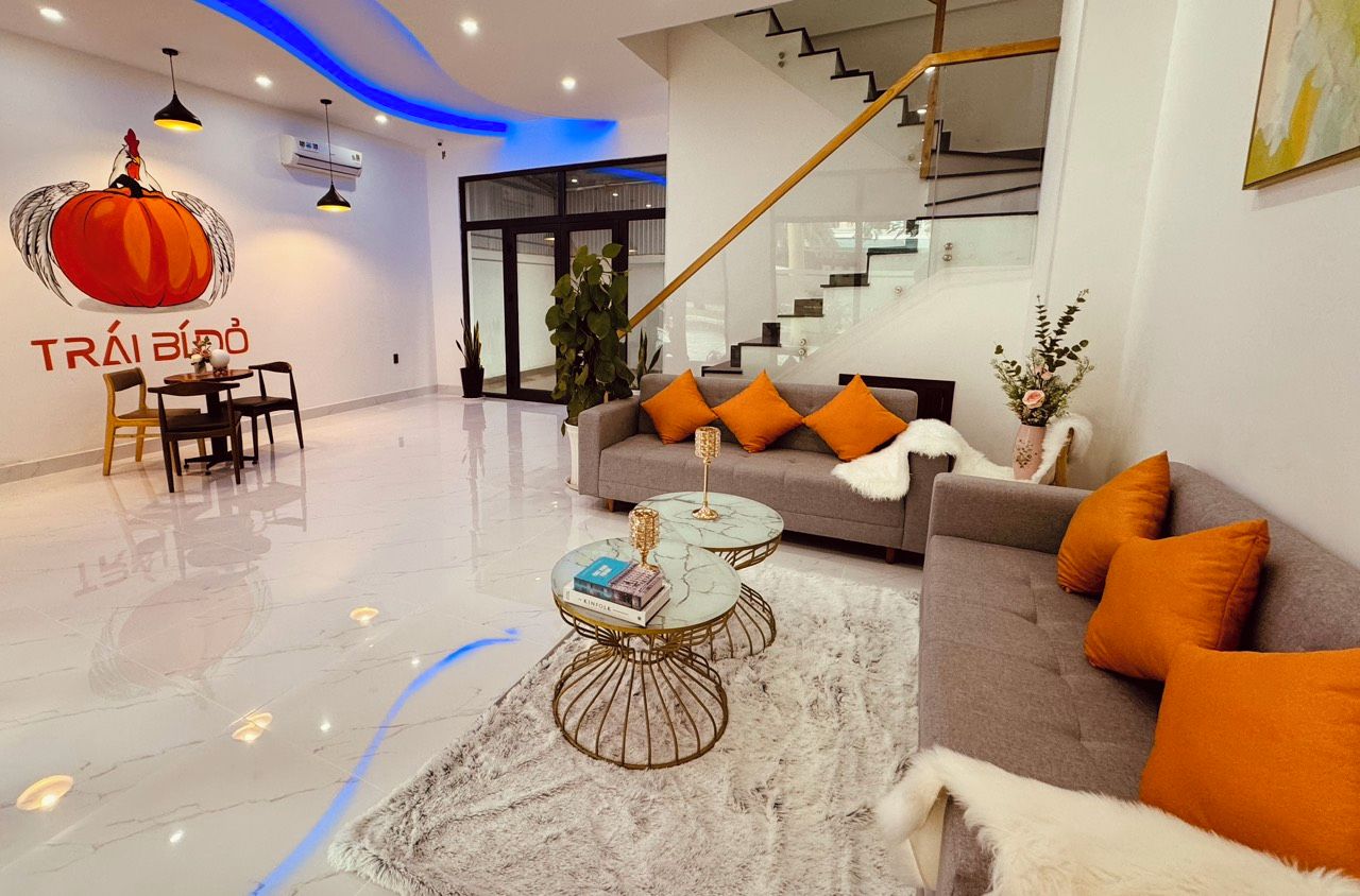 A modern living room with a sofa, two coffee tables, and a staircase.