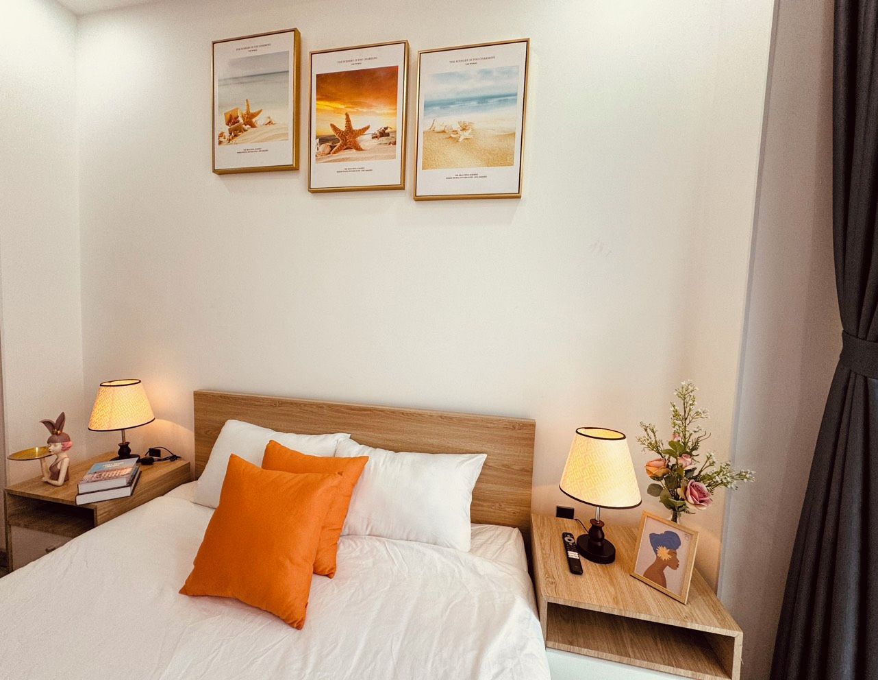 Een hotelkamer met een bed, twee nachtkastjes, een lamp, een lijst en een wanddecoratie.