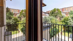 Un balcone con vista su una zona residenziale, dotato di ringhiera e porta.