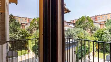 Un balcón con vistas a una zona residencial, con edificios y vegetación.