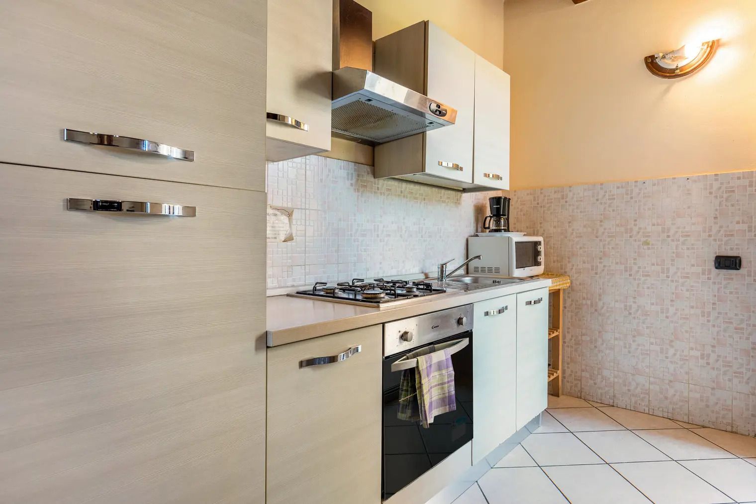 Een kleine keuken met een gasfornuis, oven en magnetron.