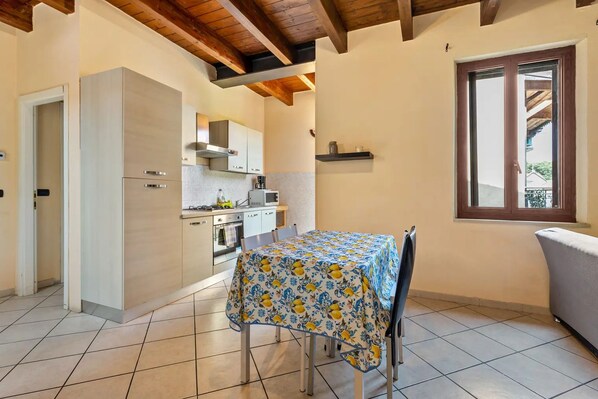 A kitchen with a dining table, cabinets, and a window. - house verona (Veneto)