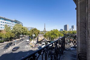 A city street with the Eiffel Tower in the background, modern buildings, and a clear sky. - The best view of the Eiffel Tower (Paris)