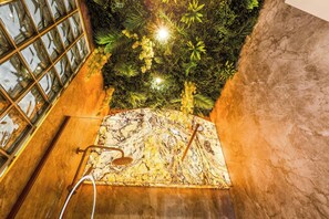 A bathroom with a marble floor, a shower, and a wall with a green plant installation. - The best view of the Eiffel Tower (Paris)