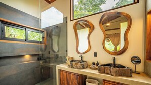 A modern bathroom with a glass shower enclosure, two wooden vanity sinks, and large mirrors. - Luxurious Beachfront Villa with Private Pool in Punta Uva (Punta Uva)