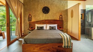 A bedroom with a large bed, wooden headboard, two bedside lamps, and a view of a balcony. - Luxurious Beachfront Villa with Private Pool in Punta Uva (Punta Uva)