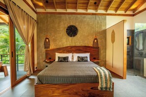 A bedroom with a large bed, wooden headboard, two bedside lamps, and a view of a balcony. - Luxurious Beachfront Villa with Private Pool in Punta Uva (Punta Uva)