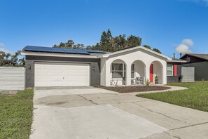 A single-story house with a garage, solar panels, and a front porch with chairs. - Fully Remodeled Brandon Escape w/ Fenced Yard! (Brandon)