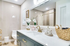 A modern bathroom with a white vanity, gold fixtures, and a large mirror. - Fully Remodeled Brandon Escape w/ Fenced Yard! (Brandon)