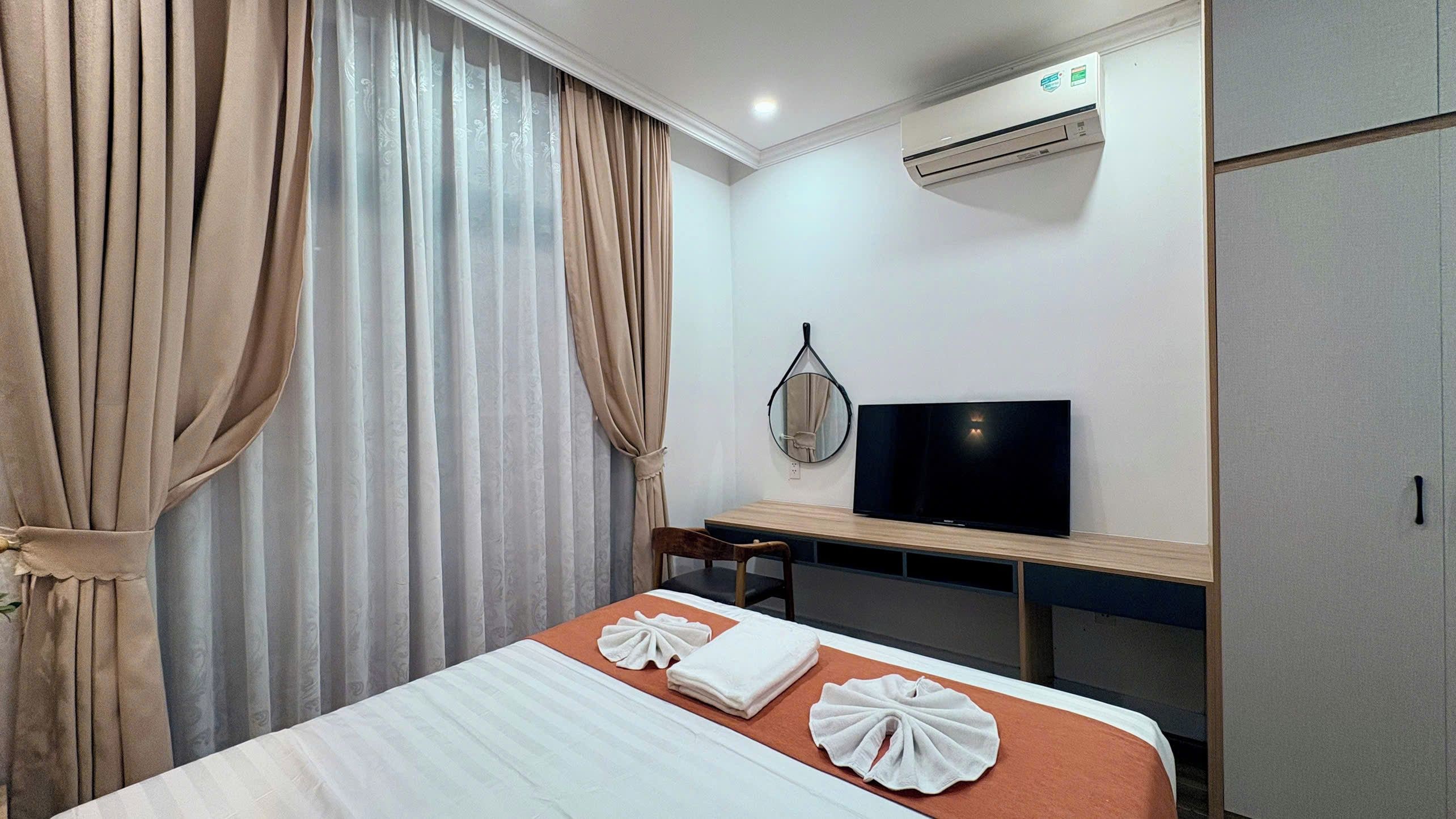 Une chambre d’hôtel équipée d’un lit, d’un bureau, d’une télévision et d’un climatiseur.