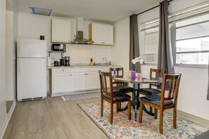 Eine kleine Küche mit weißen Schränken, einer Mikrowelle und einem Kühlschrank.