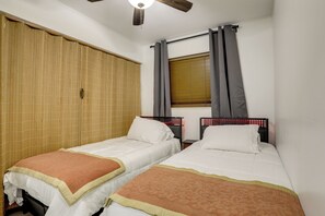 A room with two beds, a window with curtains, a ceiling fan, and a bamboo blind. - 5 Mi to Ocean! Snowbird Haven in Lake Worth Beach (Lake Worth Beach)