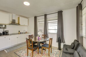Una cucina compatta con tavolo, sedie e divano.