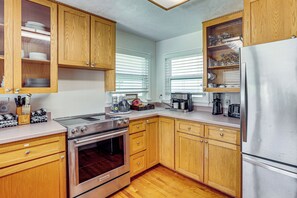 Una cocina con gabinetes de madera, estufa de acero inoxidable y refrigerador.
