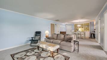 A living room with a sofa, a patterned rug, a lamp, and a chair.