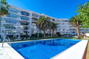 A hotel with a swimming pool, multiple balconies, and palm trees. - Studio in Nerja With Sea Views & Pool (Nerja)