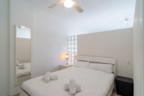 A hotel room with a bed, a nightstand, a lamp, a mirror, and a ceiling fan. - Studio in Nerja With Sea Views & Pool (Nerja)