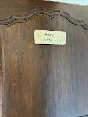 Ein Holzschrank mit einem Schild, auf dem 'Bienvenue chez Simone' steht.