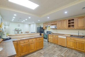 A modern kitchen with wooden cabinets, a central island, and built-in appliances. - On Main St! Walkable Family Apartment in Princeton (Princeton)