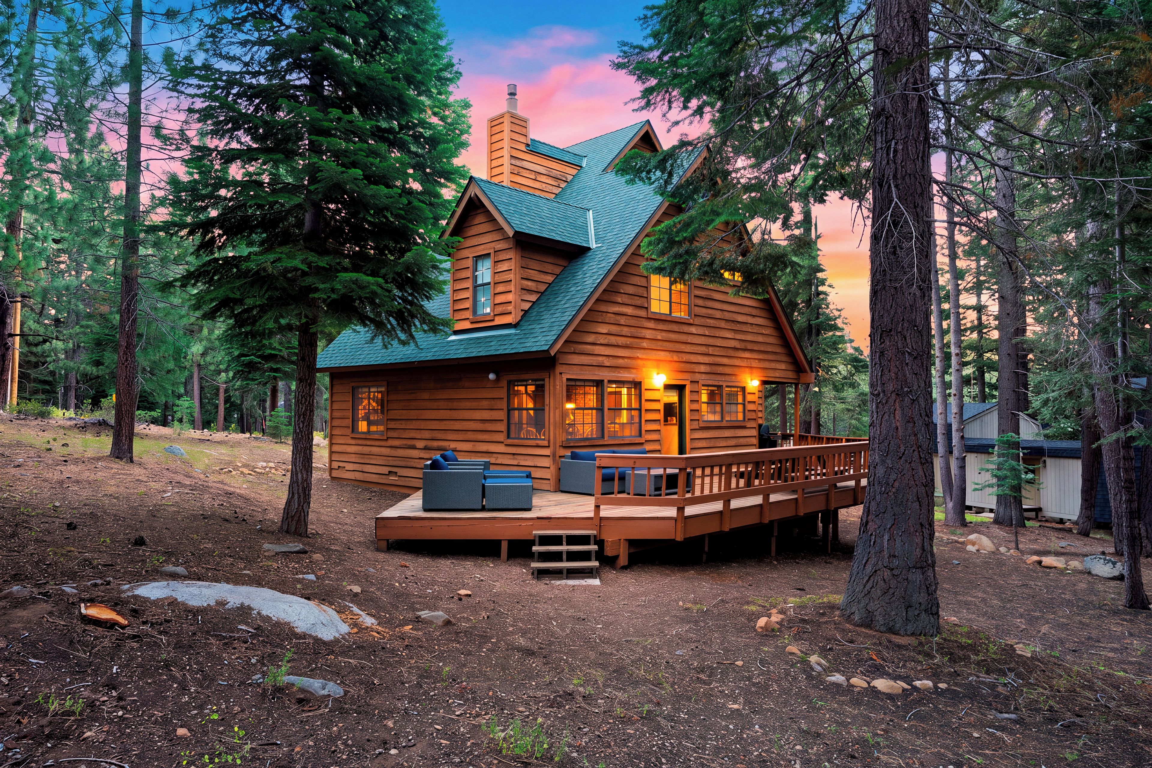 Une cabane dotée d’une terrasse, entourée d’arbres.