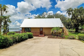 A single-story building with a flat roof, a front porch, and a small deck.