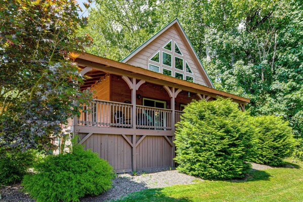 A cabin with a balcony, surrounded by dense greenery. - 5 Mi to Cataloochee Ski! Mtn-View Retreat w/ Deck (Maggie Valley)