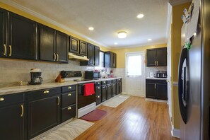A kitchen with dark cabinetry, a refrigerator, a microwave, and a stove. - 5 Mi to VIR! Private Escape w/ Yard & Decks (Milton)