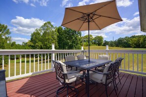 A wooden deck with a table and chairs, a white railing, and a view of a green landscape. - 5 Mi to VIR! Private Escape w/ Yard & Decks (Milton)