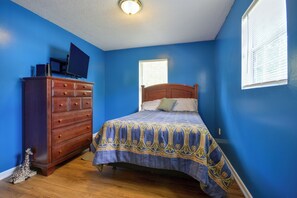 Een slaapkamer met een bed, een kaptafel en een raam.